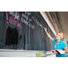 Pretty, young college/university student writing on the chalkboard/blackboa rd during a math class (color toned image; shallow DOF)