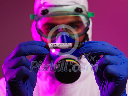Coronavirus, Doctor holding positive covid-19 virus Blood Sample tube. Wearing biohazard epidemic Protective mask, suit and glows. Coronavirus, Doctor holding positive covid-19 virus Blood Sample tube. Wearing biohazard epidemic Protective mask, suit and glows.