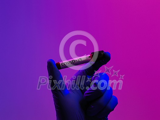 Coronavirus, Doctor holding positive covid-19 virus Blood Sample tube. Wearing biohazard epidemic Protective mask, suit and glows. Coronavirus, Doctor holding positive covid-19 virus Blood Sample tube. Wearing biohazard epidemic Protective mask, suit and glows.