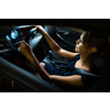 Driving a car at night - pretty, young woman driving her modern car at night, in a city (shallow DOF; color toned image)