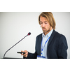 Handsome young man giving a speech at a conference