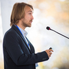 Handsome young man giving a speech at a conference