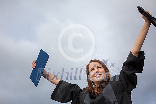 Pretty, young woman celebrating joyfully her graduation - spreading wide her arms, holding her diploma, savouring her success (color toned image; shallow DOF) Pretty, young woman celebrating joyfully her graduation - spreading wide her arms, holding her diploma, savouring her success (color toned image; shallow DOF)