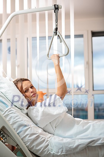 Pretty, young, female patient in a modern hospital room. Getting better fast after a surgery/illness - pensive yet positive, thinking ahead, making plans (shallow DOF; color toned image) Pretty, young, female patient in a modern hospital room. Getting better fast after a surgery/illness - pensive yet positive, thinking ahead, making plans (shallow DOF; color toned image)