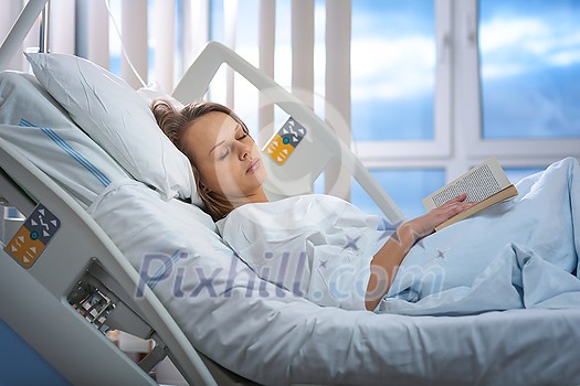 Pretty, young, female patient in a modern hospital room. Reeding a book (shallow DOF; color toned image) Pretty, young, female patient in a modern hospital room. Reeding a book (shallow DOF; color toned image)