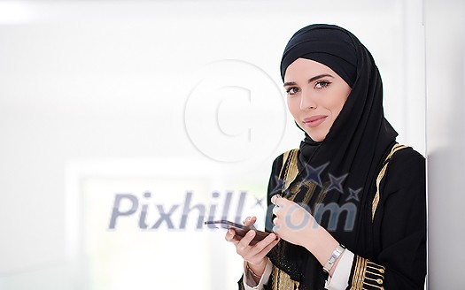young modern muslim business woman using smartphone wearing traditional hijab clothes at home young modern muslim business woman using smartphone wearing traditional hijab clothes at home