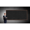 Young confident woman wearing glasses standing near blank blackboard