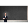 Young confident woman wearing glasses standing near blank blackboard