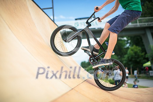 Bmx rider jumping over on a U ramp in a skatepark (motion blurred image) Bmx rider jumping over on a U ramp in a skatepark (motion blurred image)