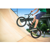 Bmx rider jumping over on a U ramp in a skatepark (motion blurred image)