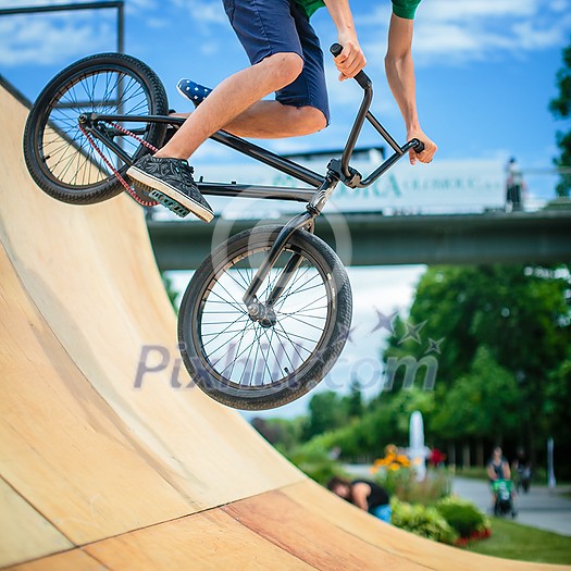 Bmx rider jumping over on a U ramp in a skatepark (motion blurred image) Bmx rider jumping over on a U ramp in a skatepark (motion blurred image)