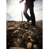 Pretty, young female hiker going uphill, crossing a snow field