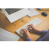 Hands of a young woman working on a computer at an office