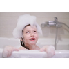 little girl playing with soap foam in bath during coronavirus stay at home pandemic quarantine