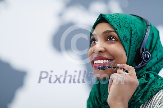 African muslim female with green hijab scarf customer representative business woman with phone headset helping and supporting online with customer in modern call centre African muslim female with green hijab scarf customer representative business woman with phone headset helping and supporting online with customer in modern call centre