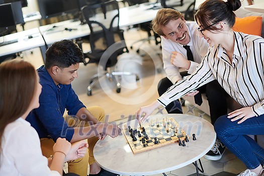 multiethnic group of business people playing chess while having a break in relaxation area at modern startup office multiethnic group of business people playing chess while having a break in relaxation area at modern startup office