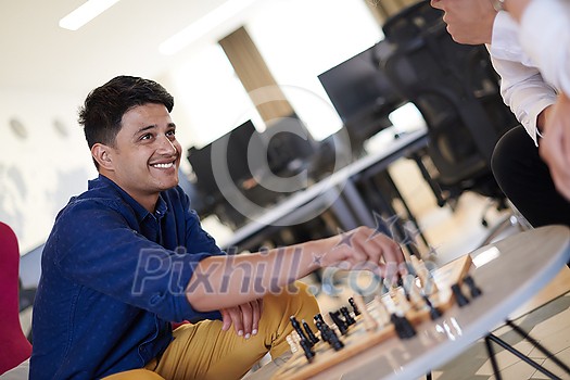 multiethnic group of business people playing chess while having a break in relaxation area at modern startup office multiethnic group of business people playing chess while having a break in relaxation area at modern startup office