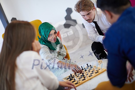 multiethnic group of business people playing chess while having a break in relaxation area at modern startup office multiethnic group of business people playing chess while having a break in relaxation area at modern startup office