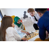 multiethnic group of business people playing chess while having a break in relaxation area at modern startup office