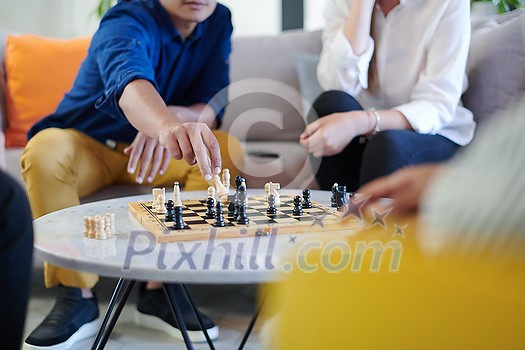 multiethnic group of business people playing chess while having a break in relaxation area at modern startup office multiethnic group of business people playing chess while having a break in relaxation area at modern startup office