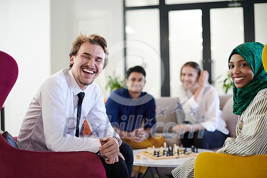 multiethnic group of business people playing chess while having a break in relaxation area at modern startup office multiethnic group of business people playing chess while having a break in relaxation area at modern startup office