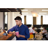 casual indian business man taking break from the work  using tablet computer while drinking tea in relaxation area of modern open plan startup office