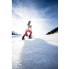 Young woman snowshoeing in high mountains, enjoying a lovely day