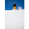 Winter sports - young man running with snowshoes downhill in high mountains covered with lots of snow