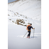 Winter sports - young man walking with snowshoes in high mountains covered with lots of snow (selective focus on the mountain in the background)