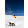 Winter sports - young man walking with snowshoes uphill in high mountains covered with lots of snow (selective focus on the mountain in the background)