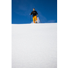 Winter sports - young man running with snowshoes downhill in high mountains covered with lots of snow