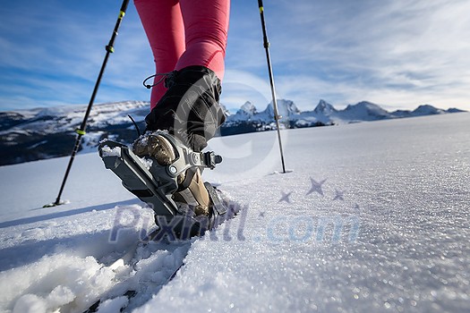 Young woman snowshoeing in high mountains, enjoying a lovely day Young woman snowshoeing in high mountains, enjoying a lovely day