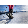 Young woman snowshoeing in high mountains, enjoying a lovely day