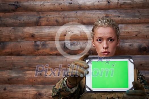 woman soldier using tablet computer against old wooden wall in camp woman soldier using tablet computer against old wooden wall in camp