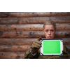 woman soldier using tablet computer  against old wooden  wall in camp