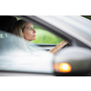 Pretty midle aged woman at the steering wheel of her car commuting to work