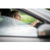 Pretty midle aged woman at the steering wheel of her car commuting to work