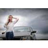 Pretty middle aged woman having car troubles - broken down car on the side of the road, calling the insurance company for assistance