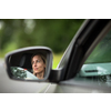 Pretty midle aged woman at the steering wheel of her car commuting to work