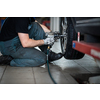 Car mechanic changind tires of a car in a repair shop/car garage (shallow DOF/color toned image)