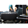 Car mechanic changind tires of a car in a repair shop/car garage (shallow DOF/color toned image)