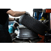 Car mechanic changind tires of a car in a repair shop/car garage (shallow DOF/color toned image)