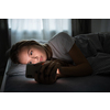 Pretty, young woman sleeping in her bed with her cell phone close to her. Smartphone in Bed Mobile/smartphone  Addiction Concept.