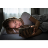 Pretty, young woman sleeping in her bed with her cell phone close to her. Smartphone in Bed Mobile/smartphone  Addiction Concept.