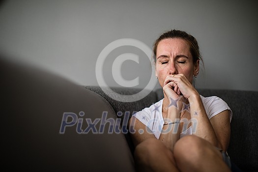 Depressed mid-aged woman at home feeling sad, lonely, anxious (color toned image) Depressed mid-aged woman at home feeling sad, lonely, anxious (color toned image)