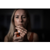 Mid-aged woman lighting a cigarette at home, getting her nicotine daily dose