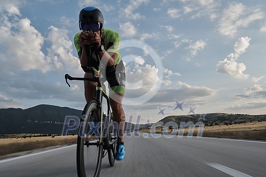 triathlon athlete riding professional racing bike at workout on curvy country road triathlon athlete riding professional racing bike at workout on curvy country road