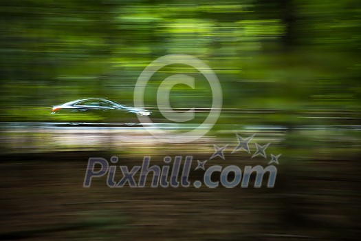 Cars going fast on an interstate road amid forests Cars going fast on an interstate road amid forests
