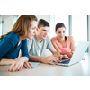 Group of three college/university students working together in library. They could not do without a laptop nowadays.
