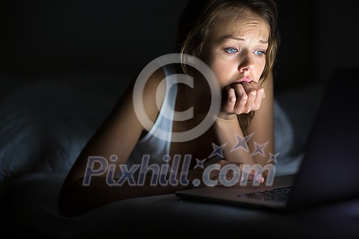 Pretty, young woman using her laptop computer in bed (color toned image; shallow DOF) Pretty, young woman using her laptop computer in bed (color toned image; shallow DOF)